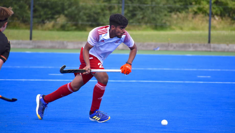 Male hockey player running with the ball