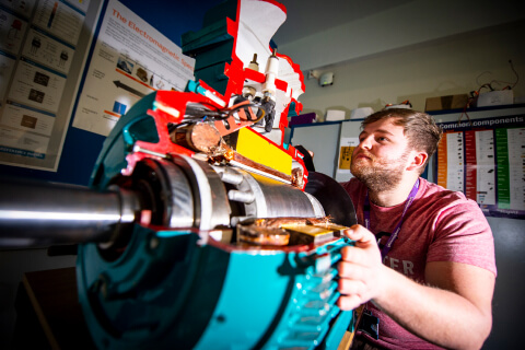 Enginering Student looking at a cross-section of an engine