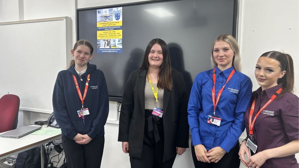 Larissa, second from left stands with current students.